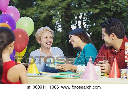 Senior Hispanic woman receiving gift at birthday party View Large Photo Image Stock Photograph - Senior Hispanic woman receiving gift at birthday party. Fotosearch