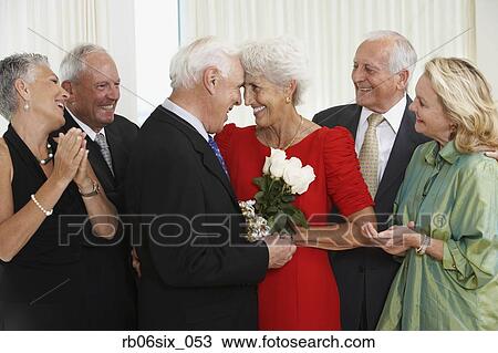 Senior man giving wife bouquet of flowers while friends watch View Large Photo Image Stock Image - Senior man giving wife bouquet of flowers while friends watch. Fotosearch