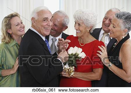 Senior man giving wife bouquet of flowers while friends watch View Large Photo Image Stock Image - Senior man giving wife bouquet of flowers while friends watch. Fotosearch