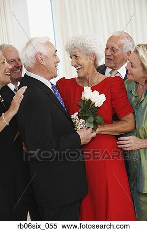 Senior man giving wife bouquet of flowers while friends watch View Large Photo Image Stock Photography - Senior man giving wife bouquet of flowers while friends watch. Fotosearch