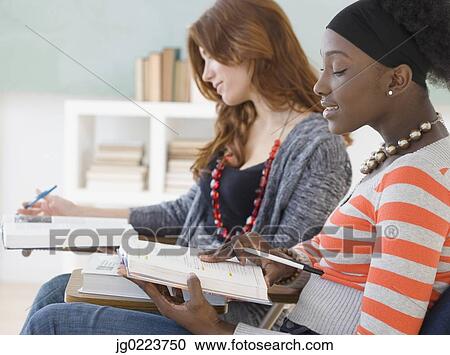 Stock Image - Two female college students studying in class. Fotosearch