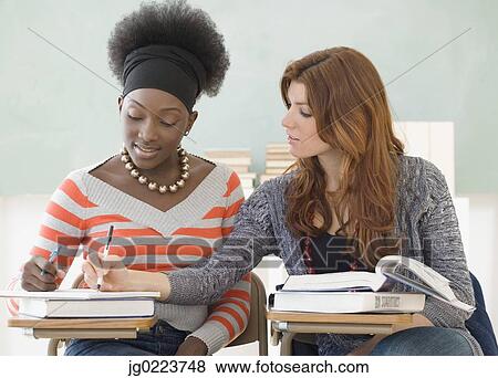 Stock Photo - Two female college students studying in class. Fotosearch