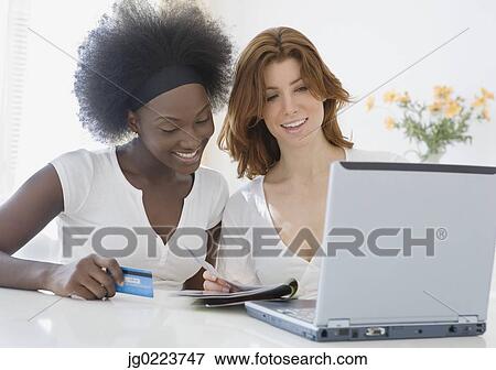 Stock Photo - Two women online shopping. Fotosearch