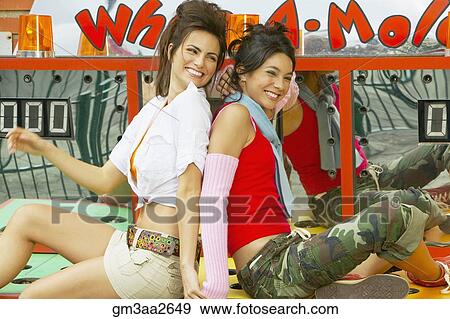 Two young Hispanic women sitting on carnival booth View Large Photo Image Stock Photo - Two young Hispanic women sitting on carnival booth. Fotosearch
