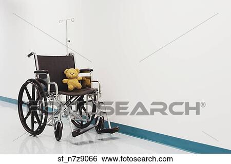 Stock Photograph - Wheelchair with teddy bear in hospital corridor. Fotosearch