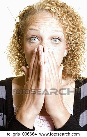 Picture - Woman covering her mouth in surprise. Fotosearch
