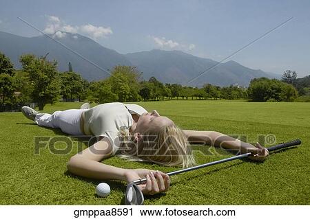 Woman laying on golf course with golf club and golf ball View Large Photo Image Stock Image - Woman laying on golf course with golf club and golf ball. Fotosearch