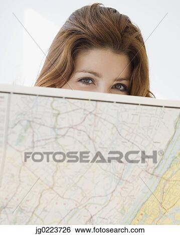 Stock Photograph - Woman looking over top of map. Fotosearch