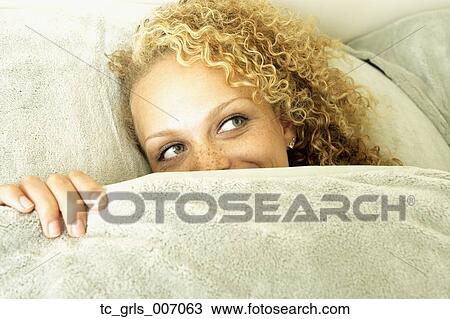 Woman peeking out from under covers in bed View Large Photo Image Stock Image - Woman peeking out from under covers in bed. Fotosearch
