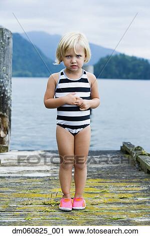 Young girl in bathing suit standing on wooden pier View Large Photo Image Stock Image - Young girl in bathing suit standing on wooden pier. Fotosearch