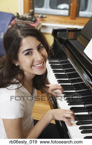 Young Hispanic woman playing piano View Large Photo Image Stock Photo - Young Hispanic woman playing piano. Fotosearch