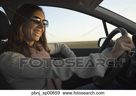 Stock Photo - Young woman driving car. Fotosearch