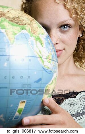 Stock Photo - Young woman holding globe. Fotosearch