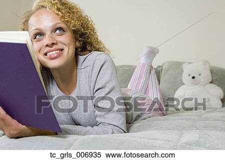 Young woman reading book on bed View Large Photo Image Stock Photography - Young woman reading book on bed. Fotosearch