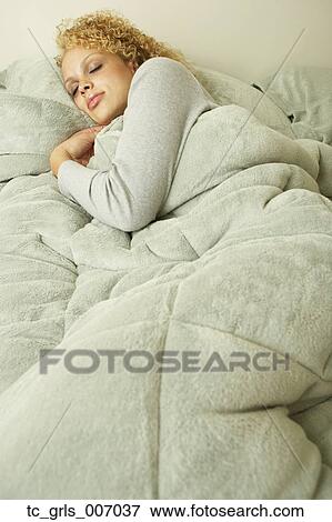 Stock Photo - Young woman sleeping in bed. Fotosearch
