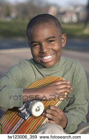 African boy holding skateboard View Large Photo Image Stock Photo - African boy holding skateboard. Fotosearch