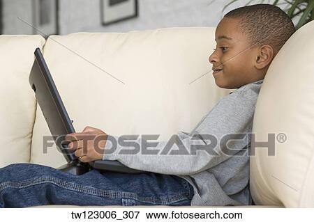 African boy looking at laptop View Large Photo Image Stock Photo - African boy looking at laptop. Fotosearch