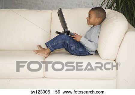 Stock Photograph - African boy looking at laptop. Fotosearch