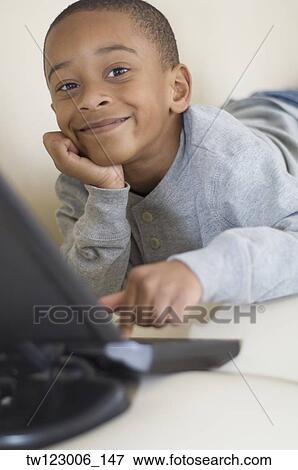 African boy typing on laptop View Large Photo Image Stock Photo - African boy typing on laptop. Fotosearch