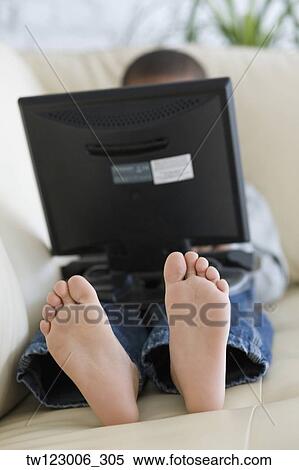 African boy using laptop on sofa View Large Photo Image Stock Photography - African boy using laptop on sofa. Fotosearch