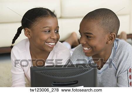 Stock Photo - African brother and sister smiling at each other. Fotosearch