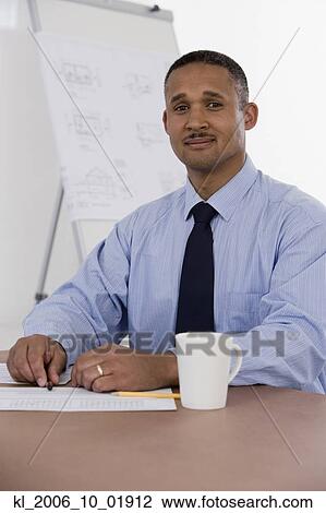 African businessman at table with paperwork View Large Photo Image Stock Image - African businessman at table with paperwork. Fotosearch