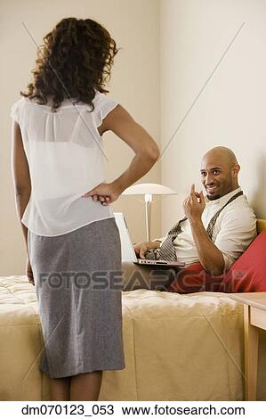 Stock Image - African businessman beckoning to wife. Fotosearch