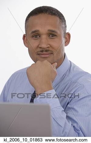 African businessman resting chin on hand View Large Photo Image Stock Image - African businessman resting chin on hand. Fotosearch