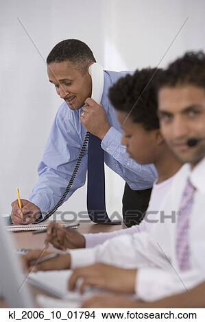 Picture - African businessman talking on telephone. Fotosearch