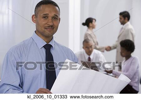 African businessman with co-workers in background View Large Photo Image Stock Image - African businessman with co-workers in background. Fotosearch