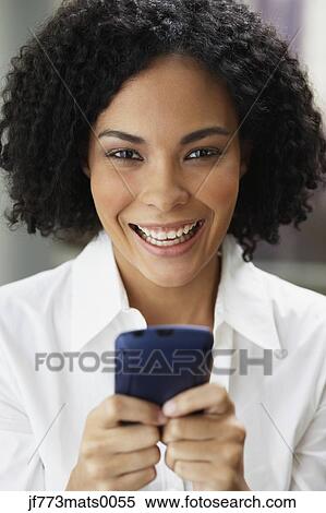 Stock Photography - African businesswoman holding cell phone. Fotosearch