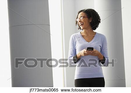 Stock Photography - African businesswoman holding cell phone. Fotosearch
