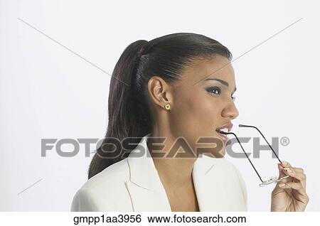 Stock Photograph - African businesswoman holding eyeglasses. Fotosearch