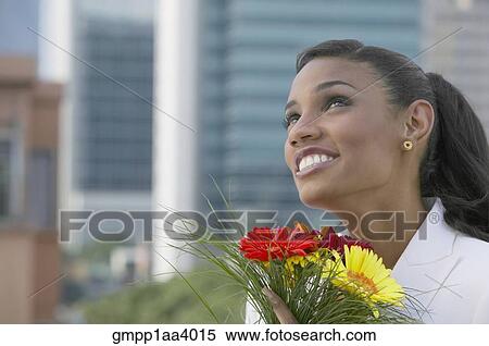 African businesswoman holding flowers View Large Photo Image Stock Photography - African businesswoman holding flowers. Fotosearch