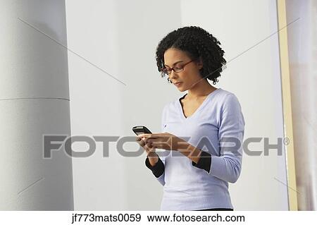 African businesswoman looking at cell phone View Large Photo Image Stock Photo - African businesswoman looking at cell phone. Fotosearch