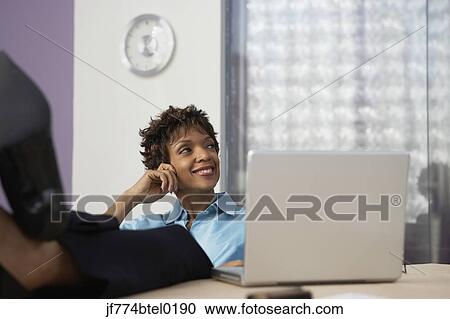 African businesswoman resting feet on desk View Large Photo Image Stock Image - African businesswoman resting feet on desk. Fotosearch