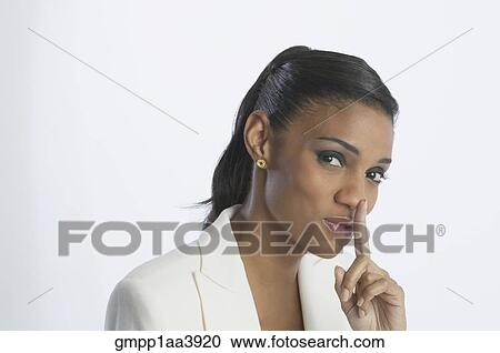 Stock Image - African businesswoman shushing. Fotosearch