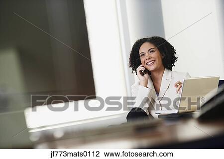Stock Image - African businesswoman talking on cell phone. Fotosearch
