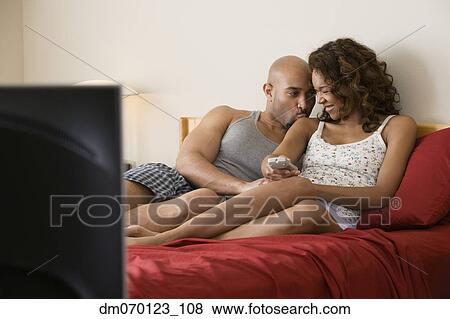 African couple cuddling in bed View Large Photo Image Stock Photo - African couple cuddling in bed. Fotosearch
