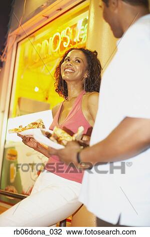 African couple eating pizza on sidewalk View Large Photo Image Stock Image - African couple eating pizza on sidewalk. Fotosearch