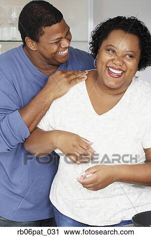 Stock Image - African couple hugging and laughing. Fotosearch