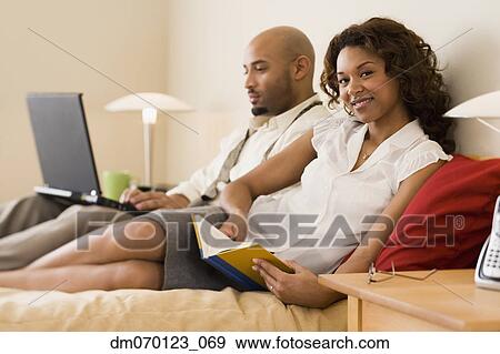 African couple relaxing in bed View Large Photo Image Stock Photo - African couple relaxing in bed. Fotosearch