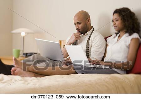 African couple typing on laptops View Large Photo Image Stock Photo - African couple typing on laptops. Fotosearch