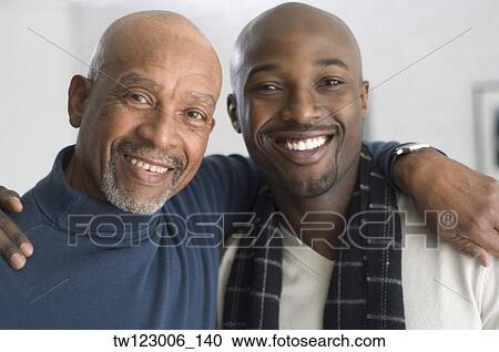 Stock Image - African father and adult son hugging. Fotosearch