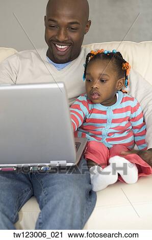 African father and daughter looking at laptop View Large Photo Image Stock Image - African father and daughter looking at laptop. Fotosearch