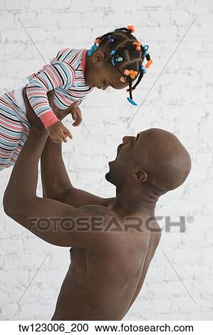Stock Image - African father playing with daughter. Fotosearch
