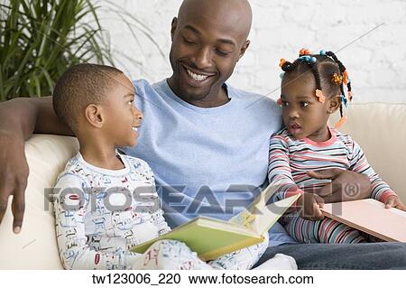 Stock Image - African father reading to children. Fotosearch