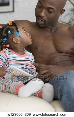 African father reading to daughter View Large Photo Image Stock Photo - African father reading to daughter. Fotosearch