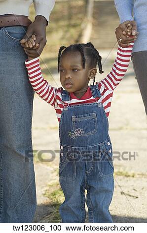 African girl holding hands with parents View Large Photo Image Stock Image - African girl holding hands with parents. Fotosearch