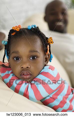 African girl on sofa with father in background View Large Photo Image Stock Image - African girl on sofa with father in background. Fotosearch